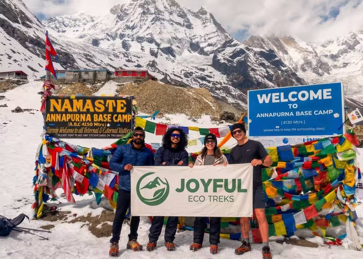 Group holding a Joyful Eco Treks banner at Annapurna Base Camp